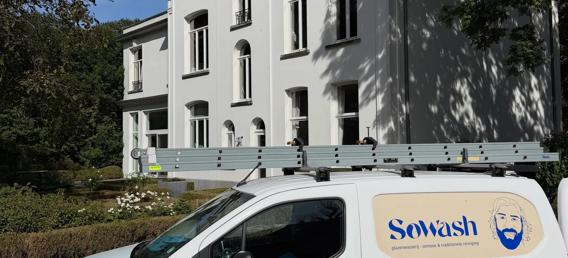 Witte villa met hoge ramen, de SoWash-bestelwagen met ladder voor de deur
